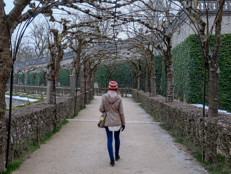 Frau mit roter Mütze läuft durch symmetrischen Garten Würzburg