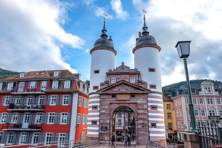 old gate with white towers and archway at end of bridge heidelberg germany