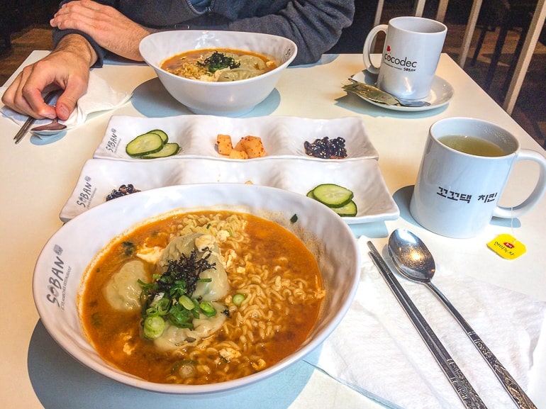 bowl of korean noodles on table with other food