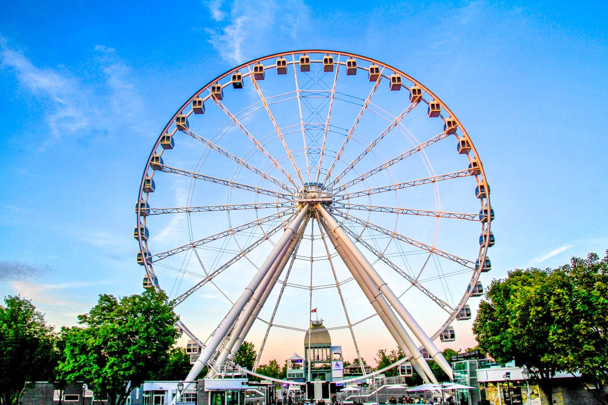 large ferris wheel seen at dusk with blue sky behind.